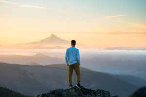 Mann auf Berg mit Aussicht